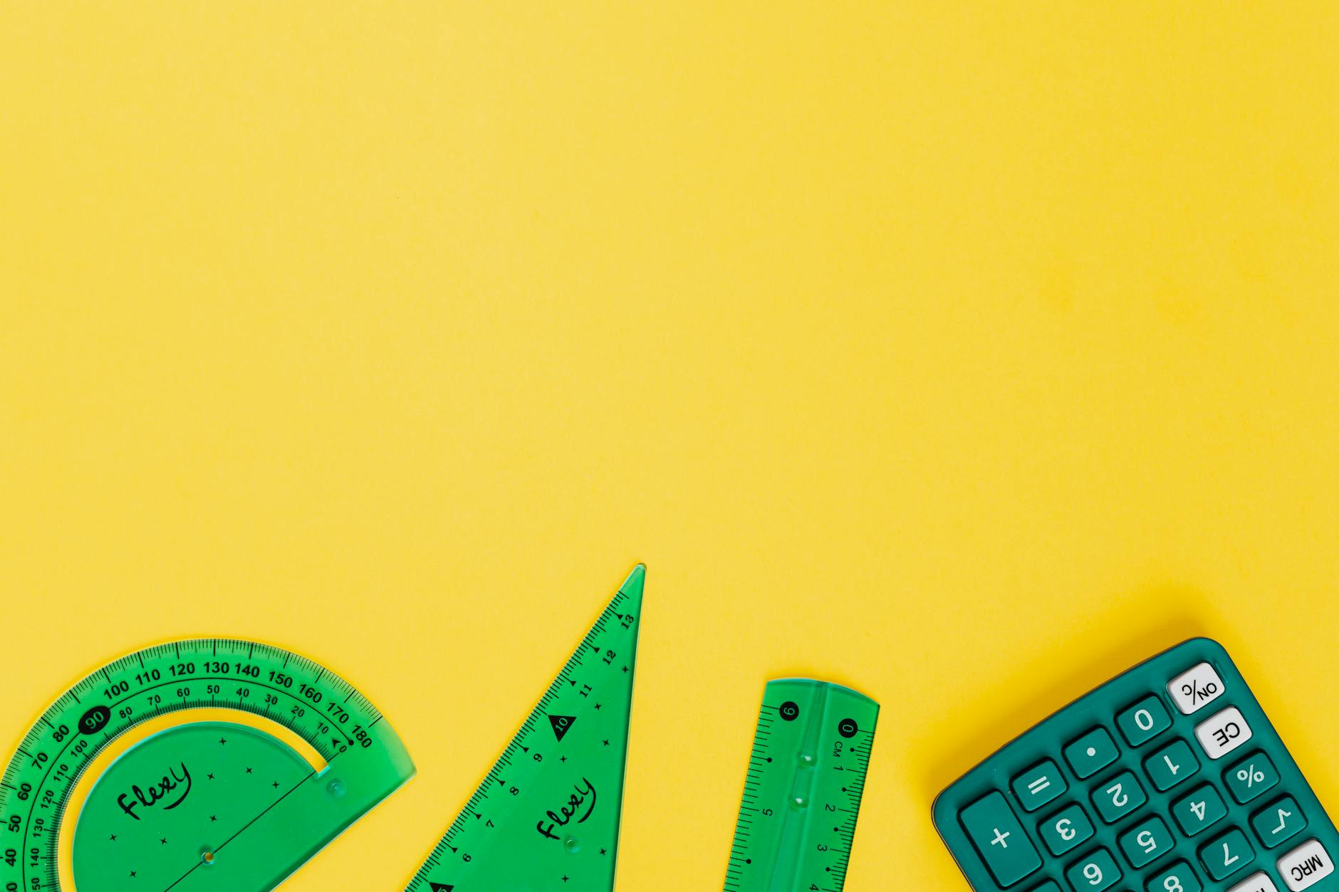 Kalkulator i kolorowe linijki na żółtym tle