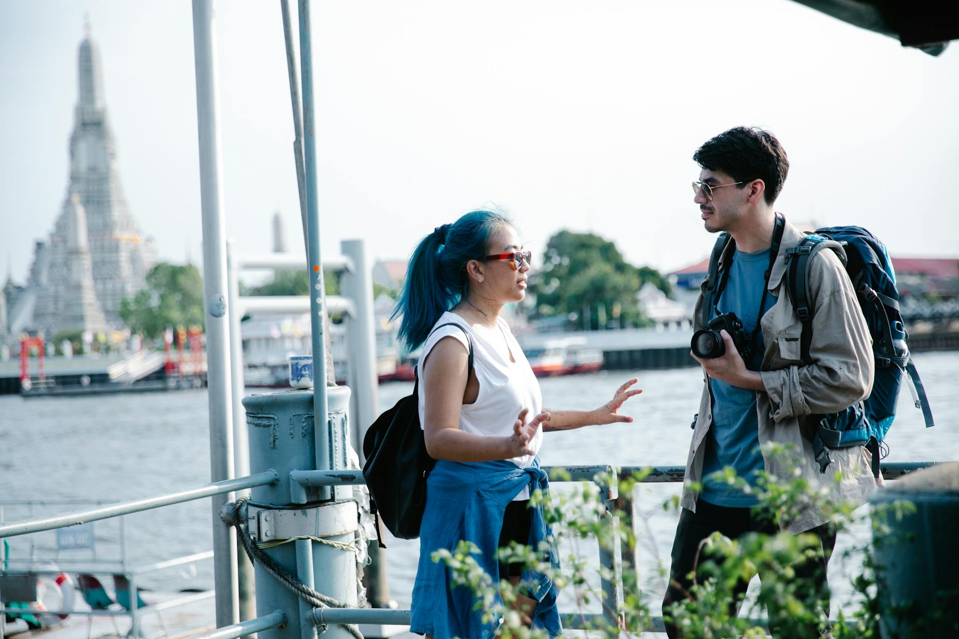 Podróżnicy rozmawiają nad rzeką przy świątyni Wat Arun w Bangkoku