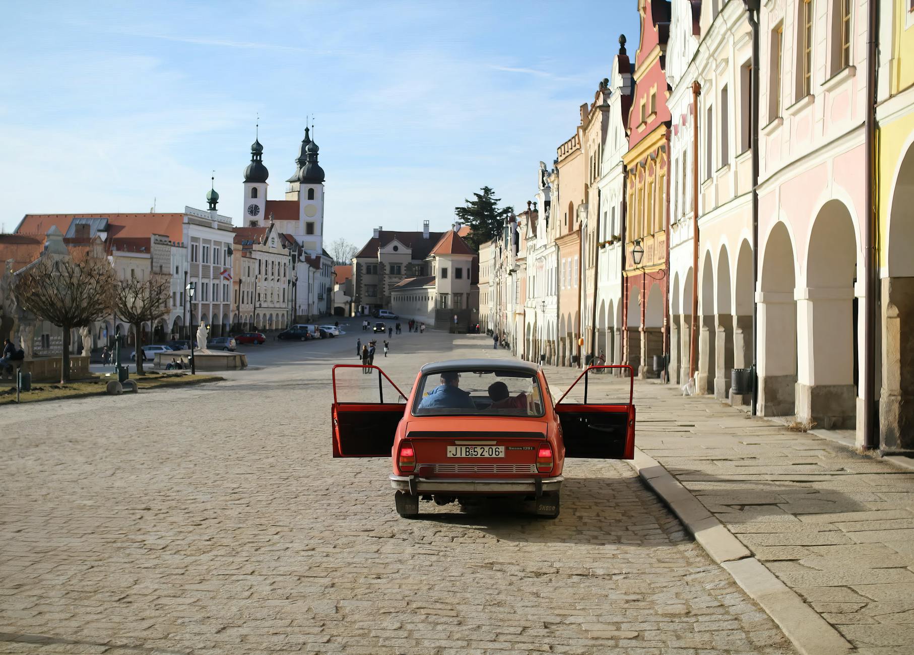 Zabytkowe auto z otwartymi drzwiami na malowniczym rynku w Czechach