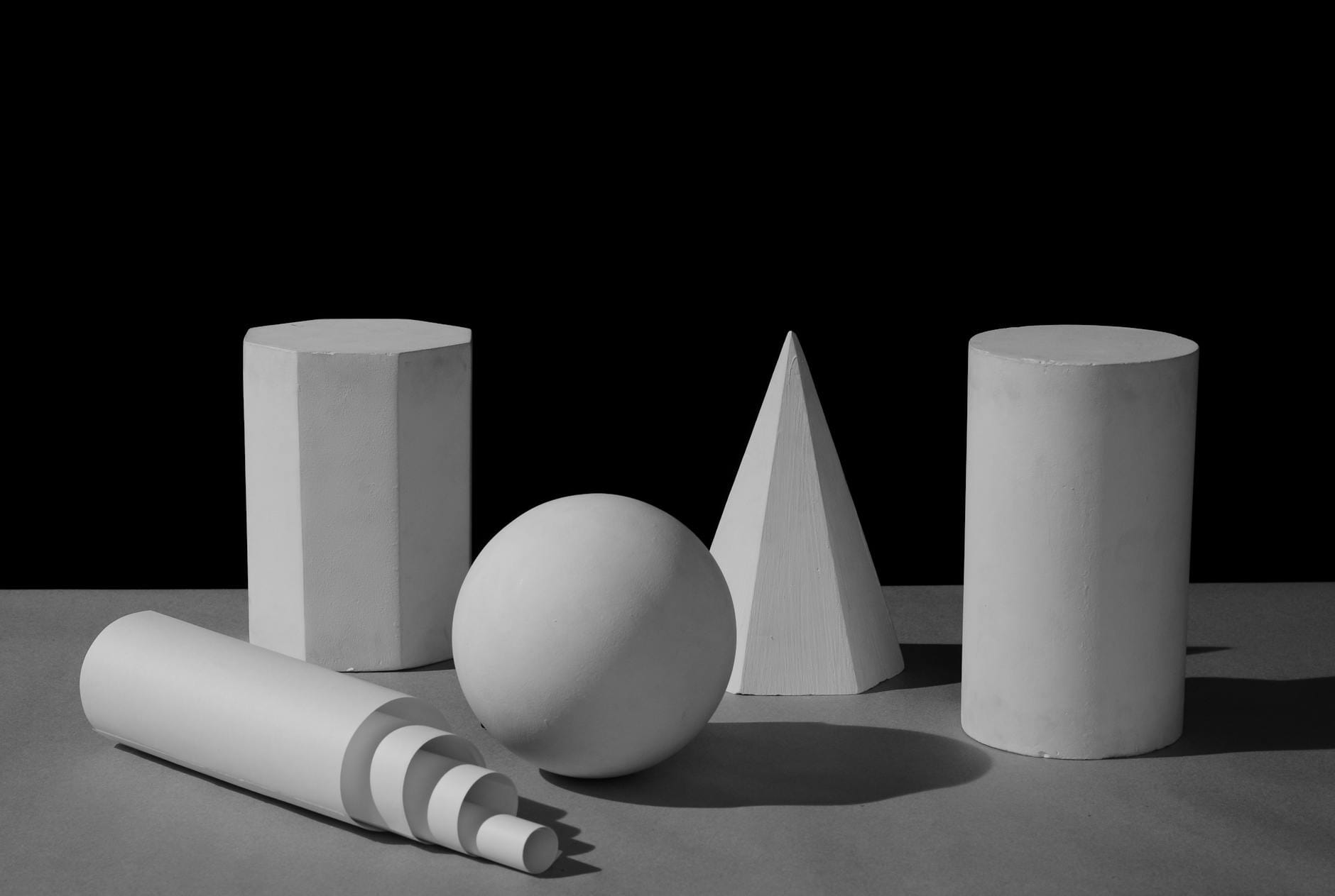 Czarno-białe bryły geometryczne oświetlone ostrym światłem