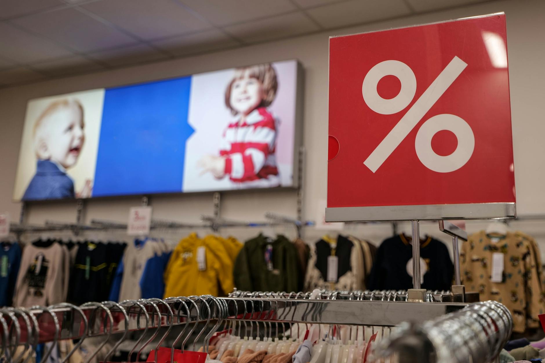 Sklep z odzieżą dziecięcą z dużym szyldem wyprzedaży i promocji