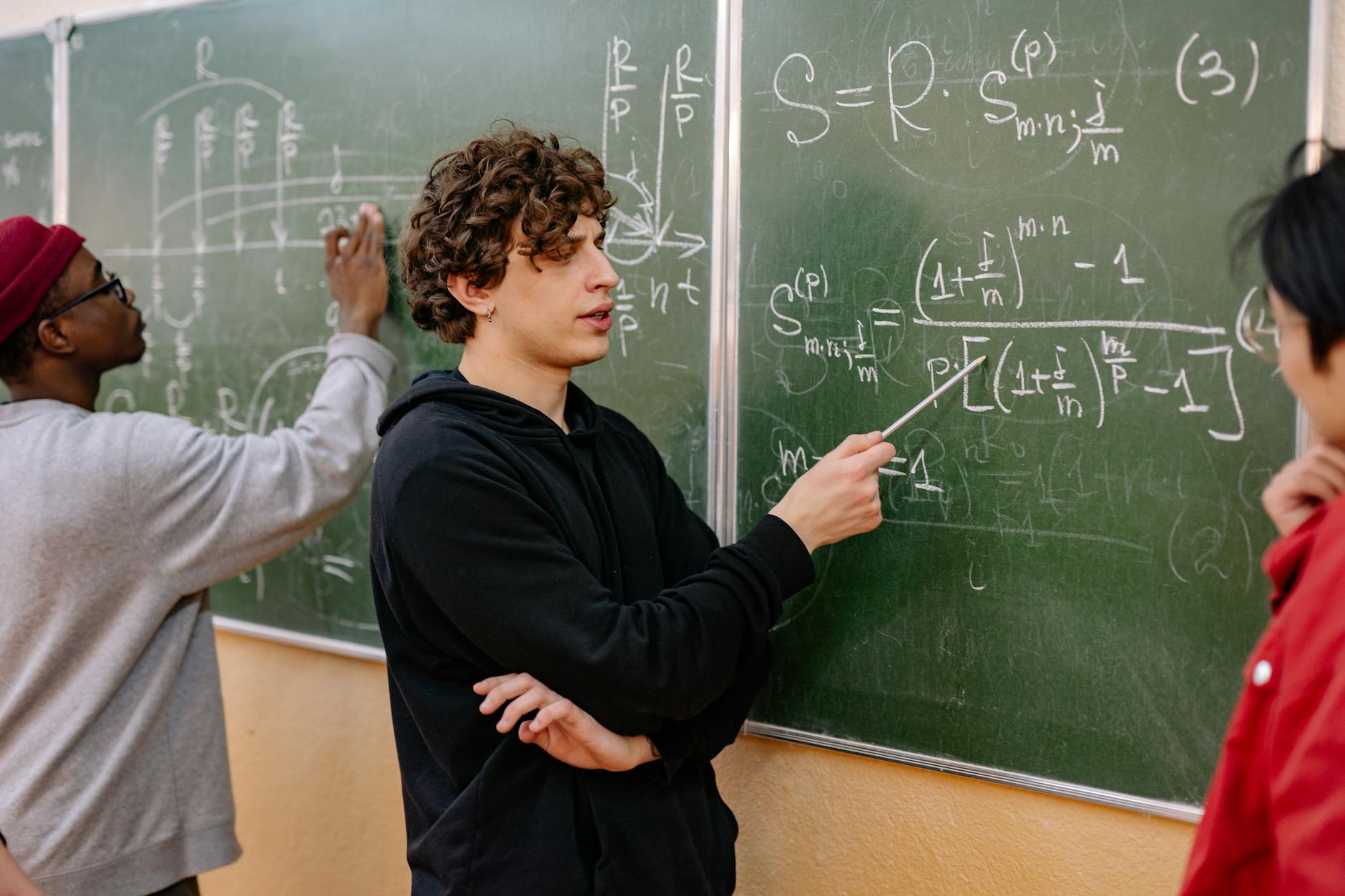 Studenci przy tablicy analizują złożone równania z prawdopodobieństwa
