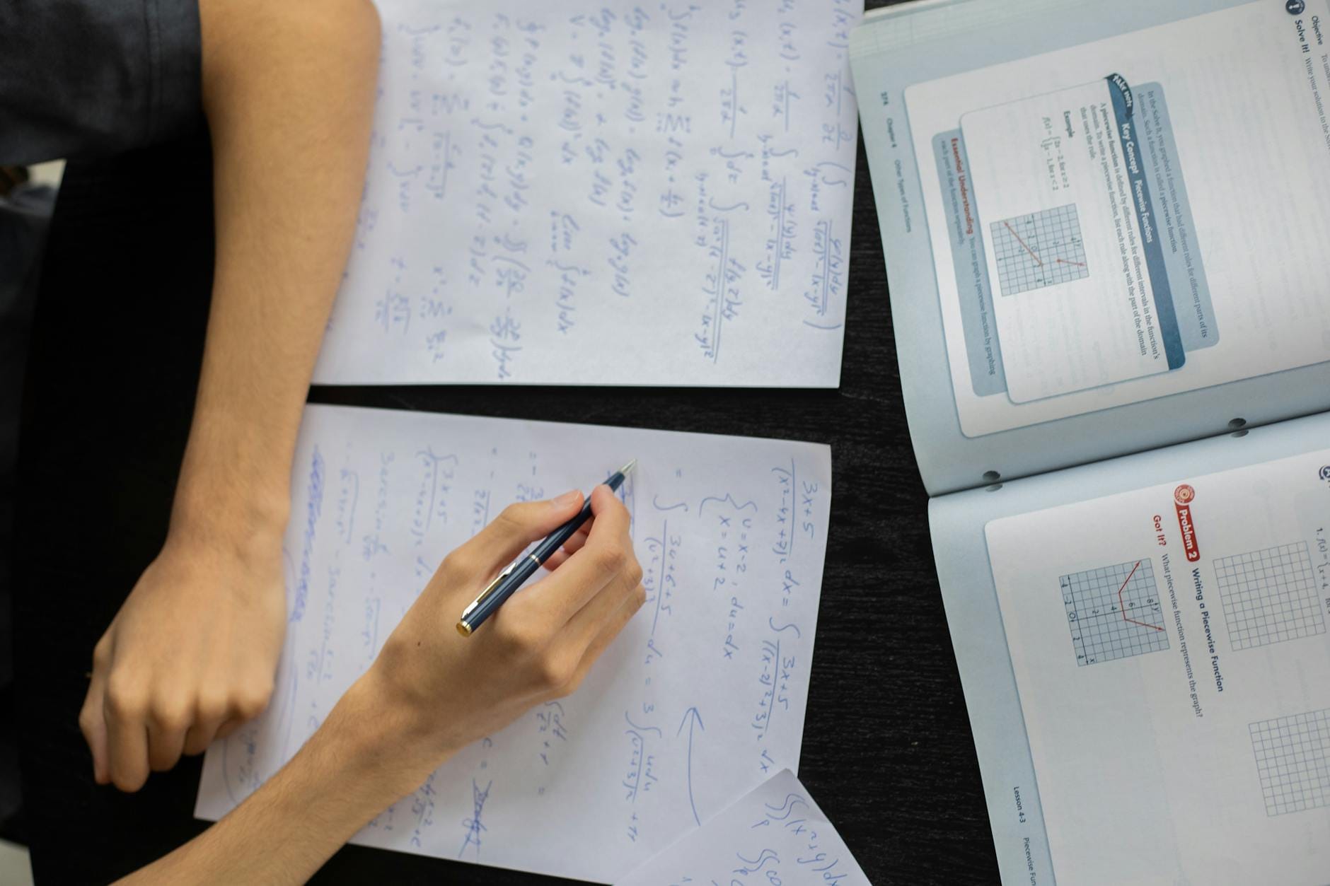 Uczeń zapisuje na kartce rozwiązania równań podczas lekcji matematyki