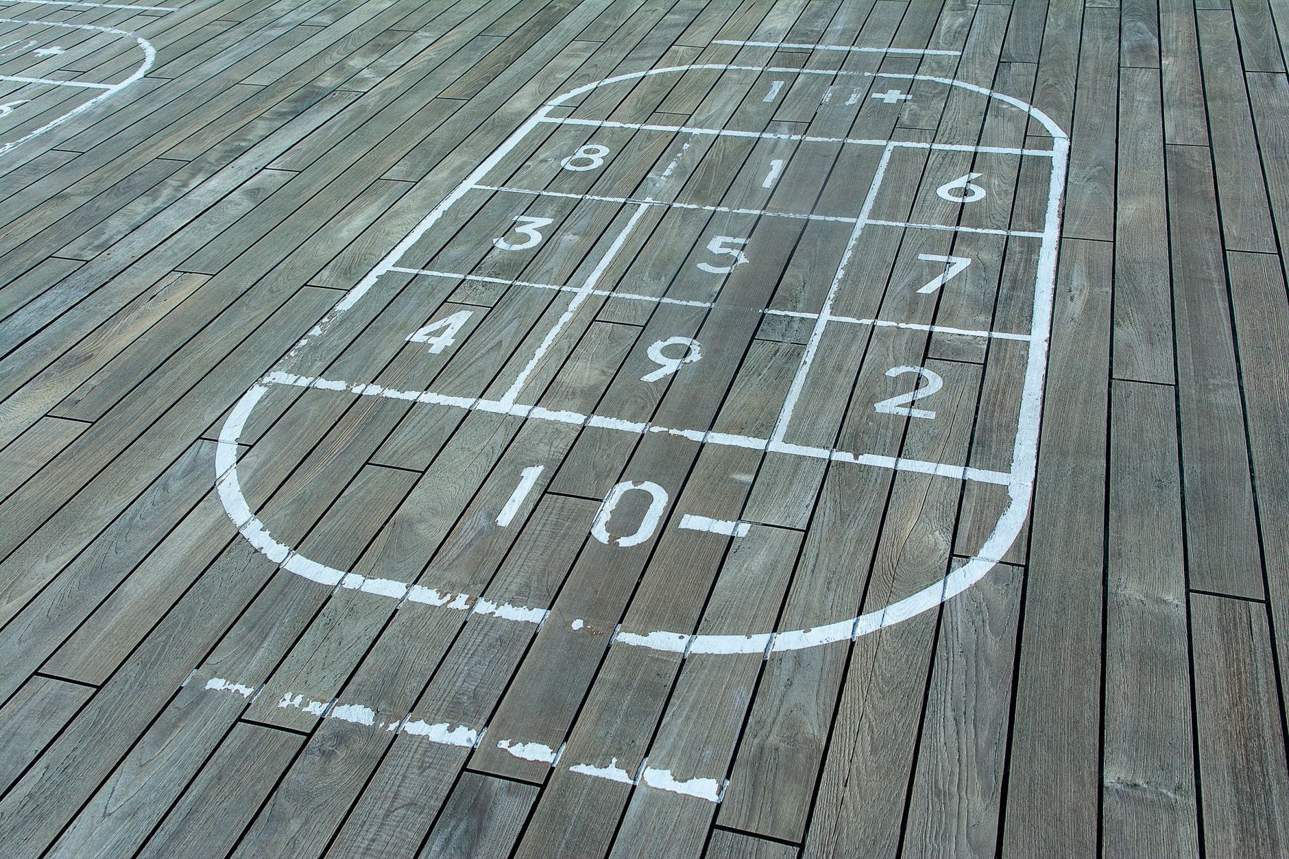 Boisko do shuffleboardu z ponumerowaną siatką na drewnianych panelach