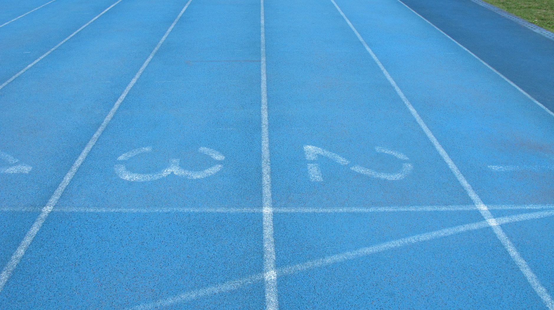 Niebieska bieżnia lekkoatletyczna z białymi numerami torów