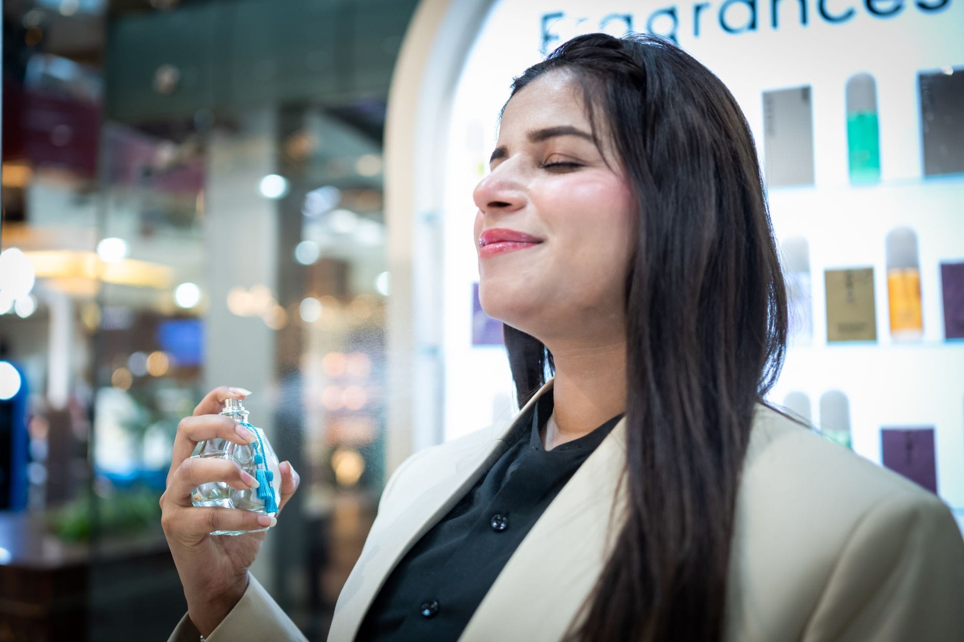 Elegancka kobieta testuje niszowe perfumy w butiku Elegancka kobieta testuje niszowe perfumy w butiku