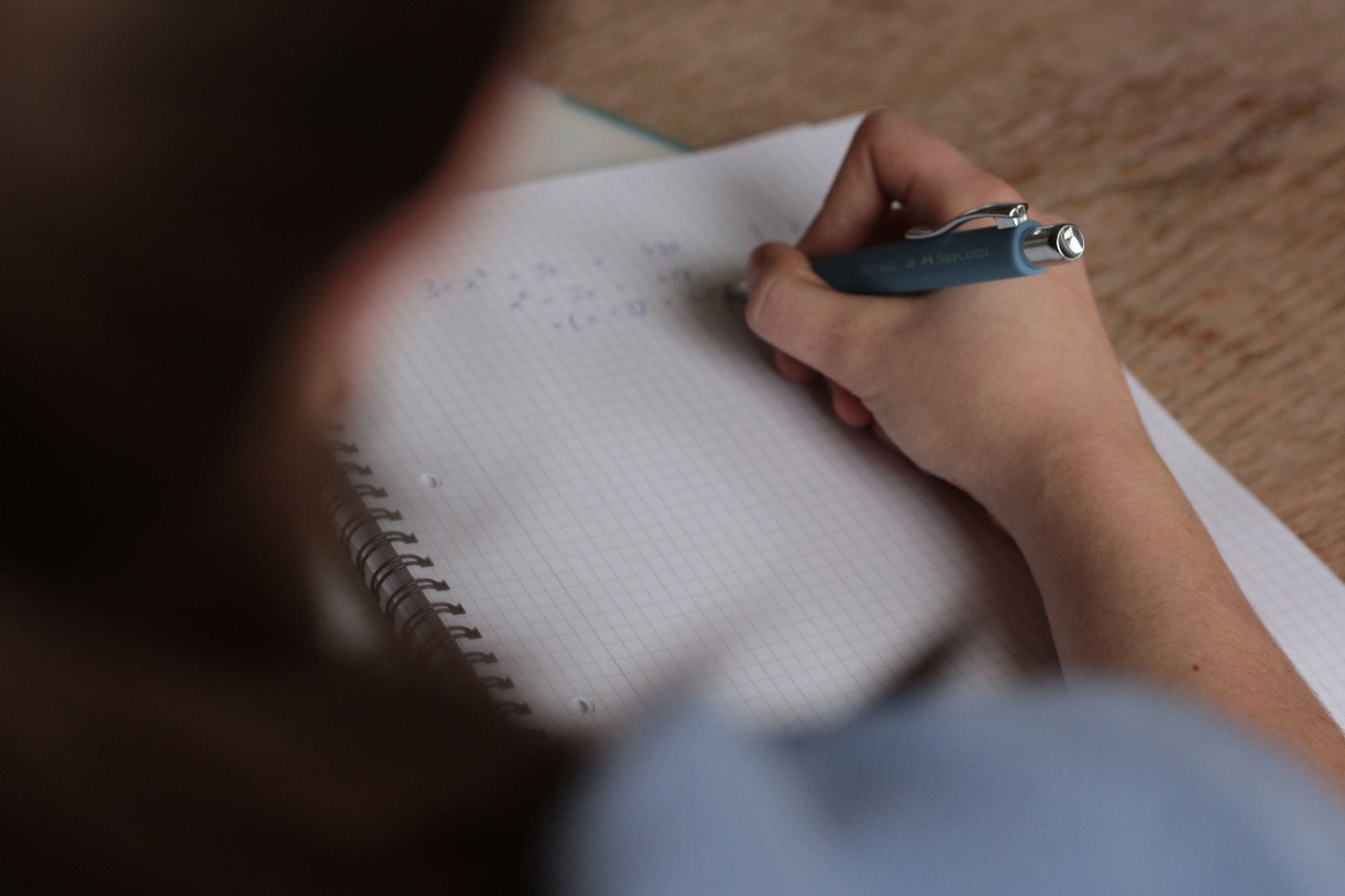 Uczeń zapisuje w zeszycie notatki z matematyki przed egzaminem ósmoklasisty Uczeń zapisuje w zeszycie notatki z matematyki przed egzaminem ósmoklasisty